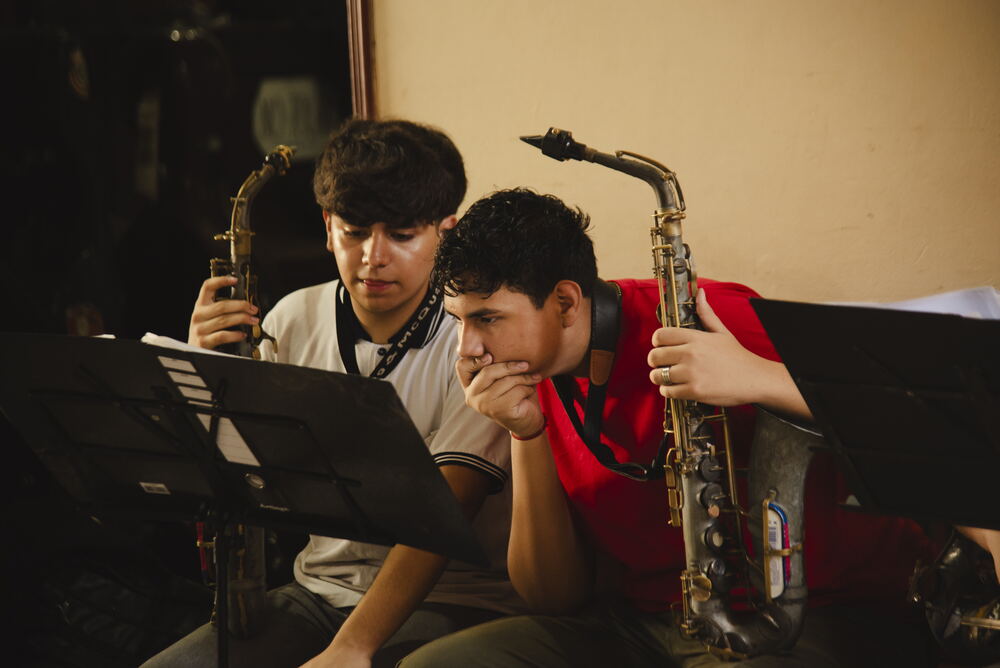 Zwei Saxophonisten über den Noten Zwei Saxophonisten beugen sich gemeinsam über ihre Noten